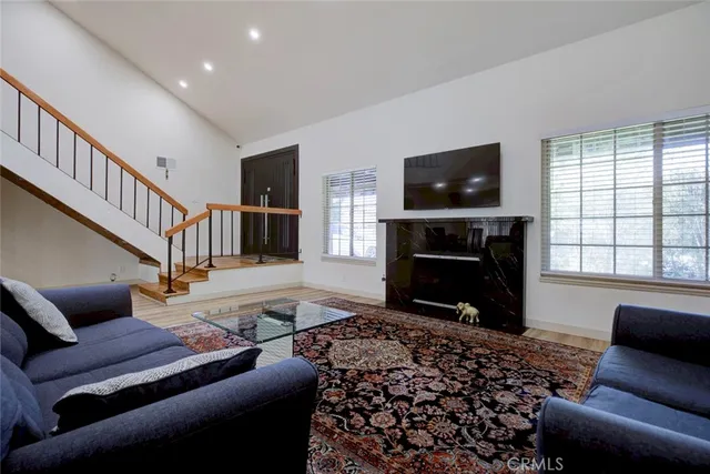 a living room with furniture a flat screen tv and a fireplace