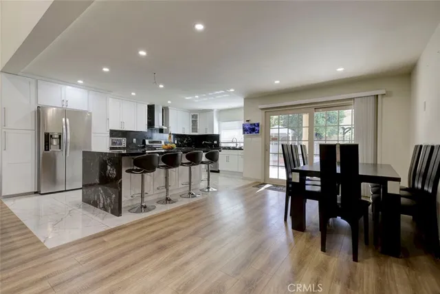 a kitchen with stainless steel appliances kitchen island granite countertop a dining table chairs and granite counter tops