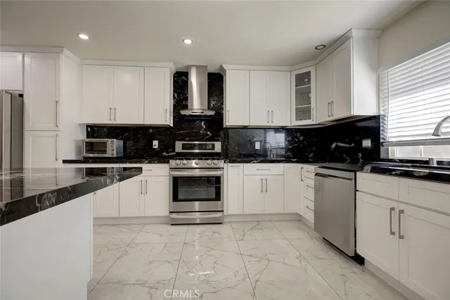 a kitchen with stainless steel appliances granite countertop a stove a sink and a microwave
