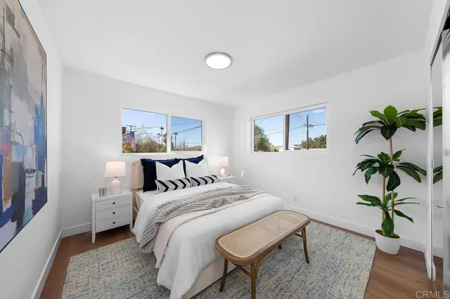 a bedroom with a bed lamp and a potted plant