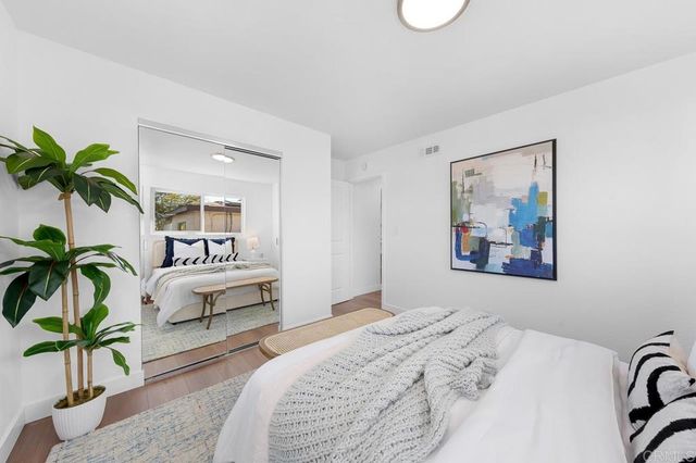 a bedroom with a large bed and a potted plant