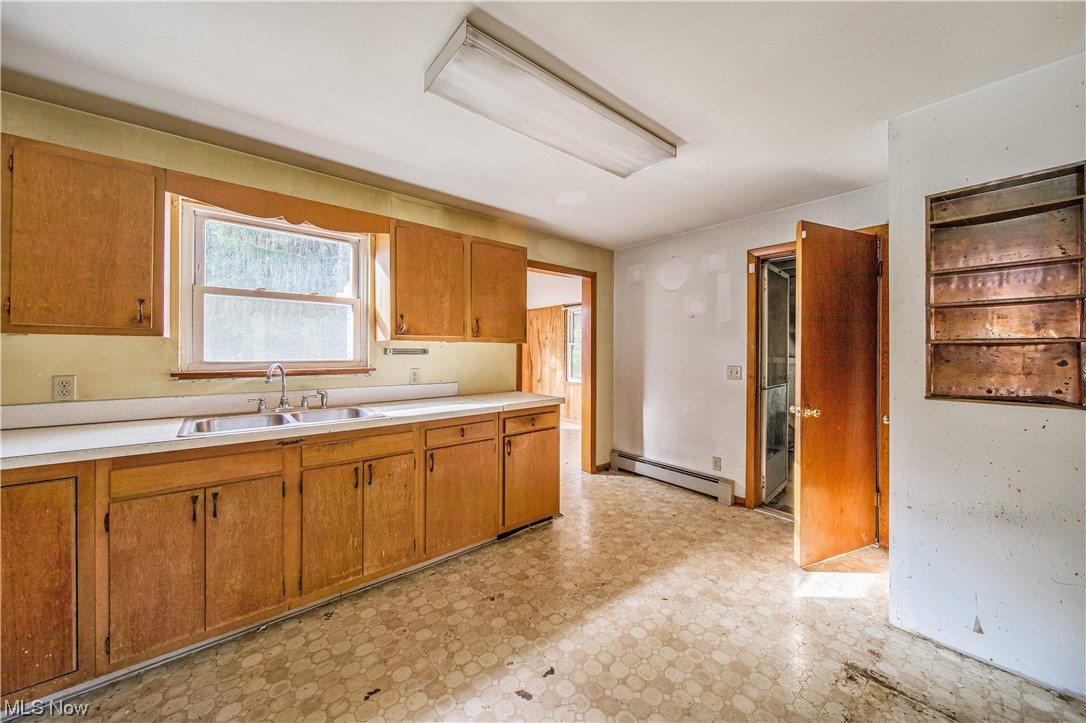 1168 Garrison Road Ashtabula, OH 44004 - Photo 26 of 35 Kitchen with sink, baseboard heating, and light tile floors