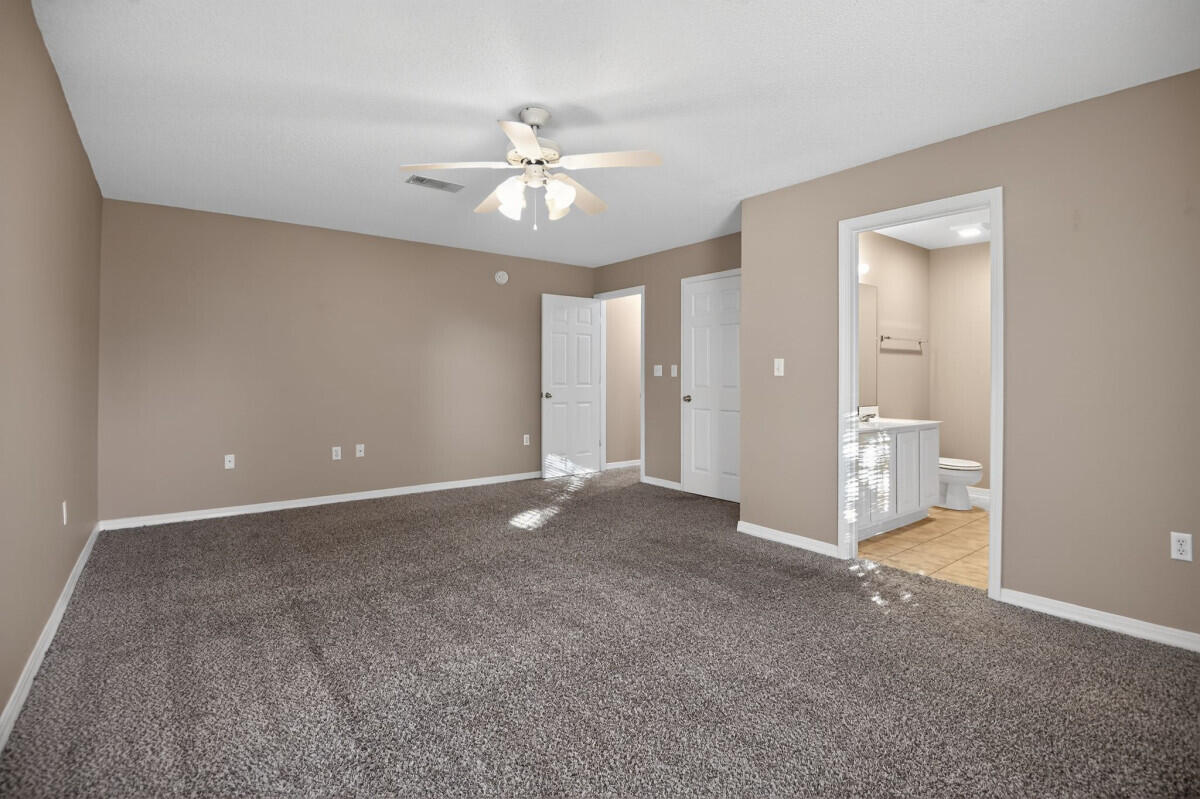 4654 Sunsail Circle Destin, FL 32541 - Photo 11 of 22 an empty room with fan and way to kitchen