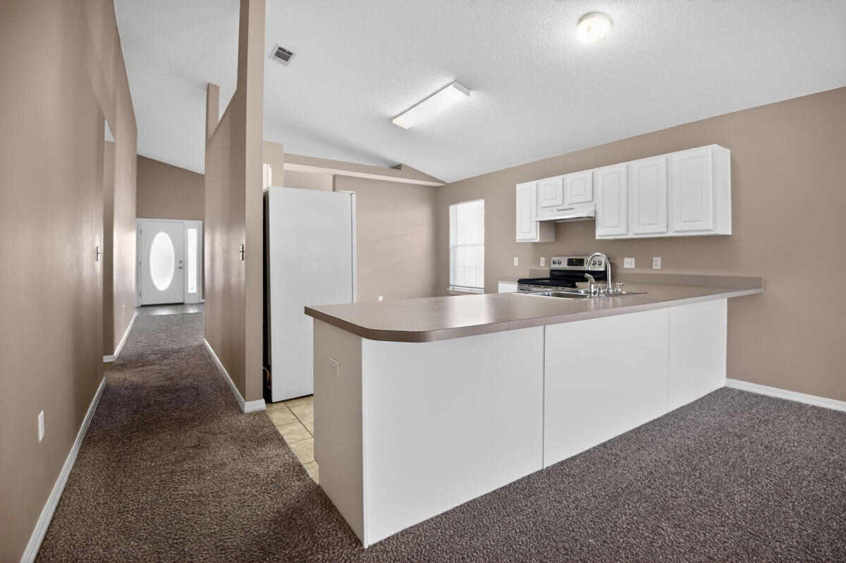 4654 Sunsail Circle Destin, FL 32541 - Photo 7 of 22 a kitchen that has a lot of white cabinets and stainless steel appliances
