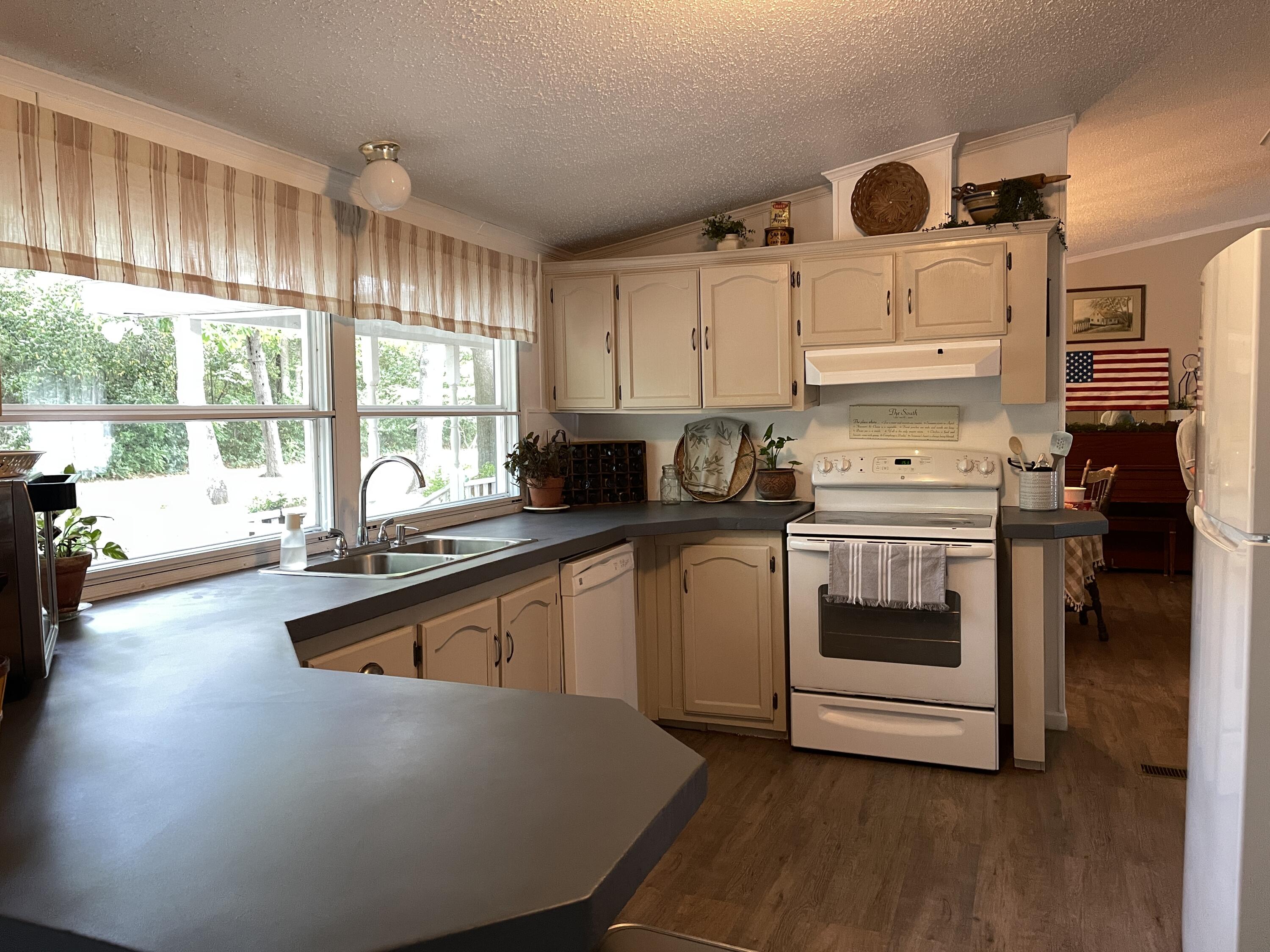 2166 Healing Springs Road Blackville, SC 29817 - Photo 9 of 43 a kitchen with a stove a sink and white cabinets with wooden floor