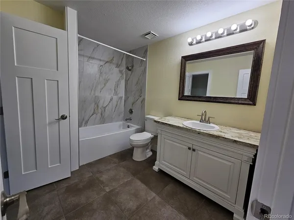 a bathroom with a double vanity sink toilet mirror and bathtub