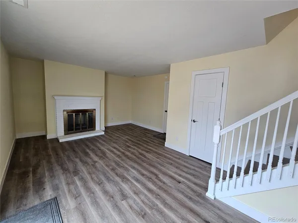 a view of a livingroom with wooden floor and a fireplace
