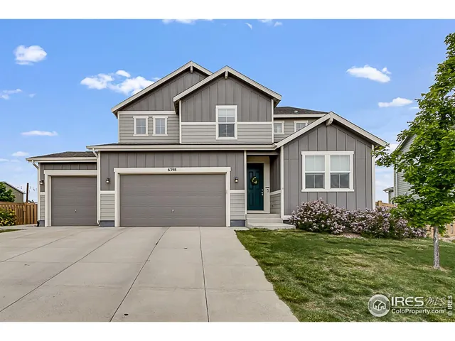a front view of a house with a garden and yard