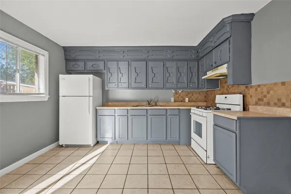 a kitchen with a stove a refrigerator and a sink