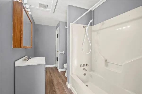 a bathroom with a tub sink and mirror