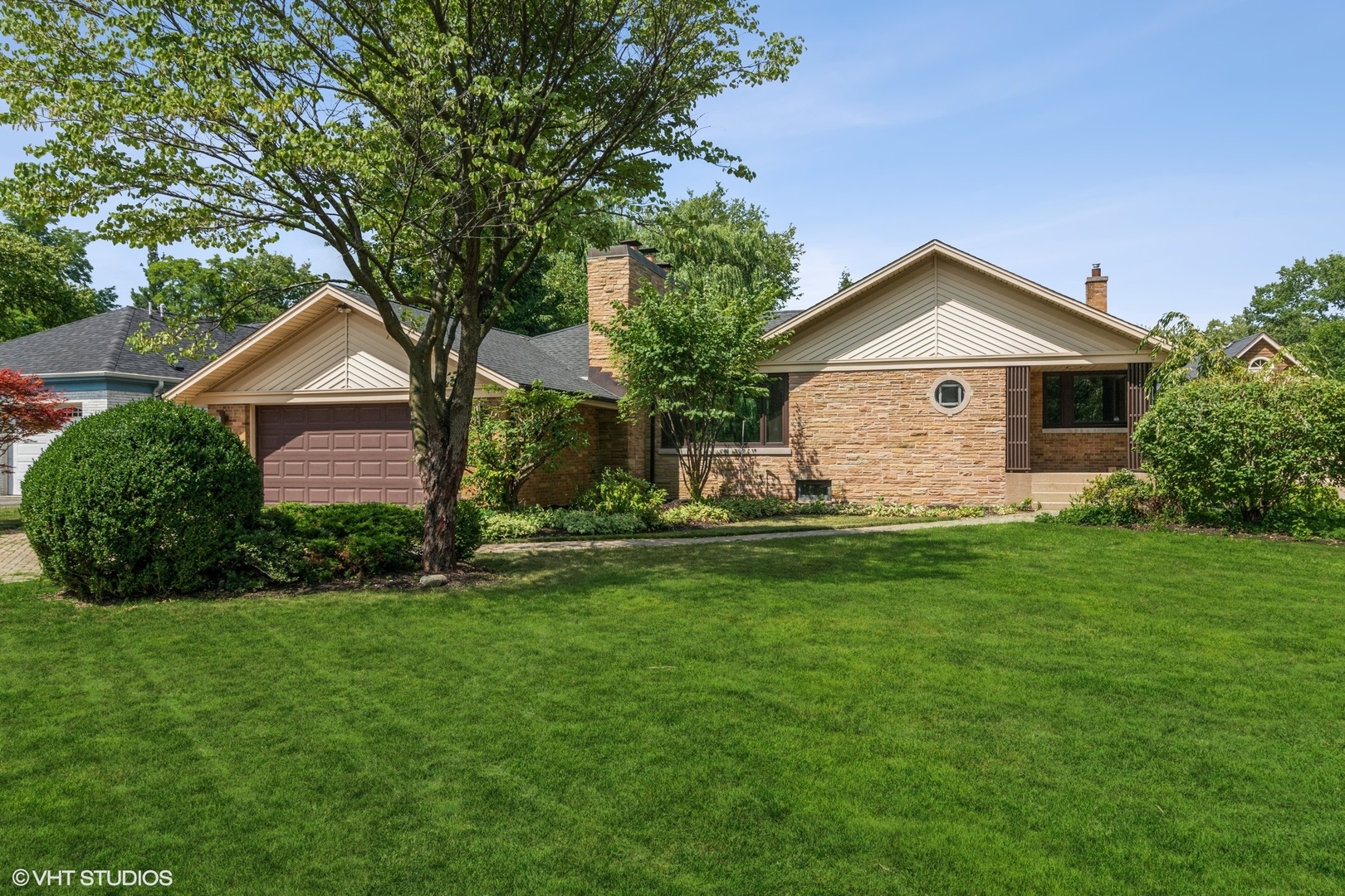 a front view of a house with a garden and yard