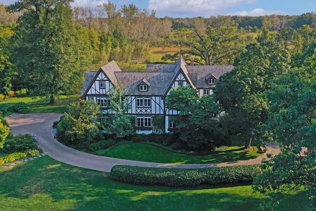 a view of a house with a big yard plants and large trees