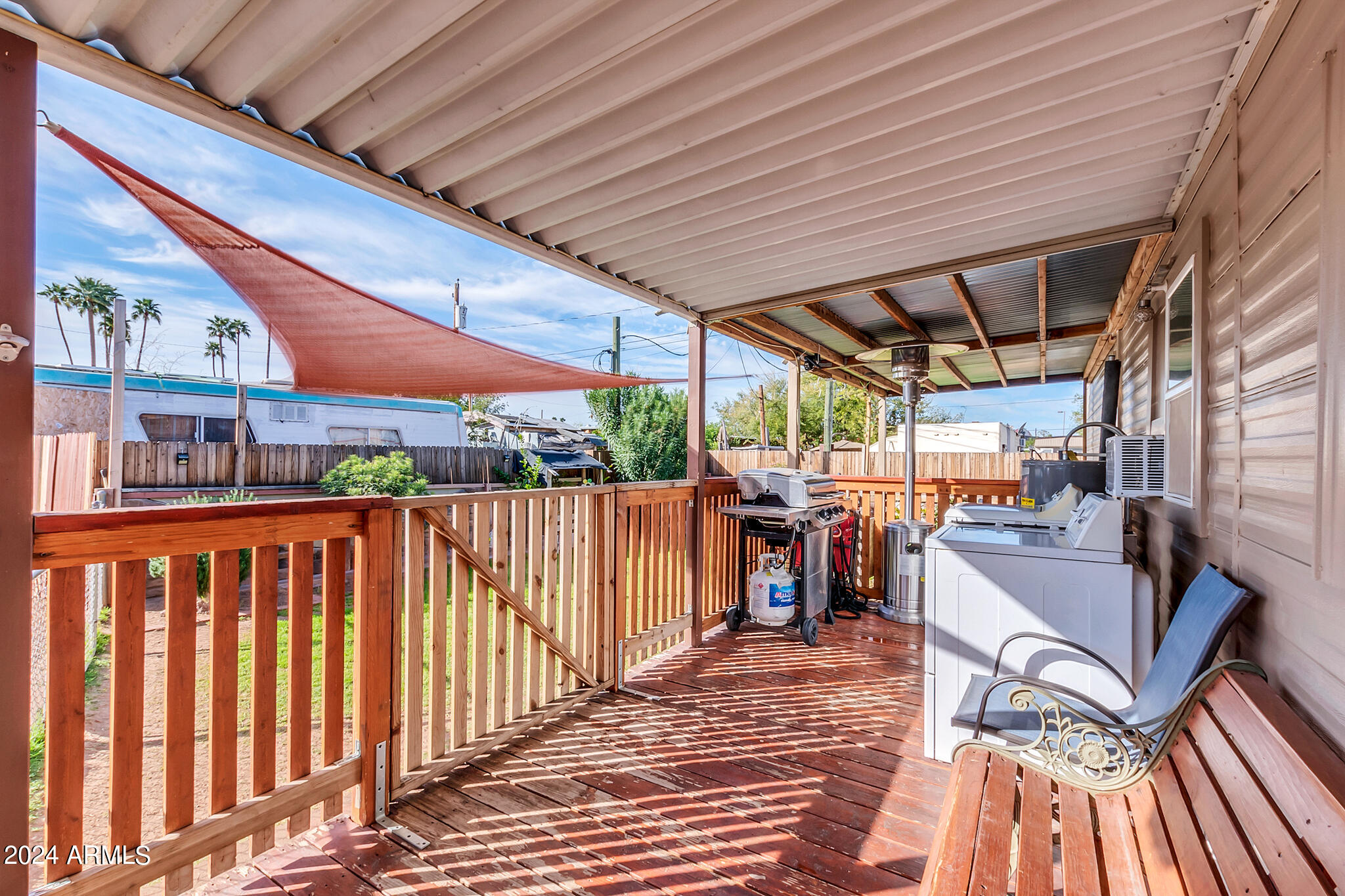 130 East McKellips Road, Unit 48 Mesa, AZ 85201 - Photo 18 of 24 a view of a patio with table and chairs with wooden floor and fence