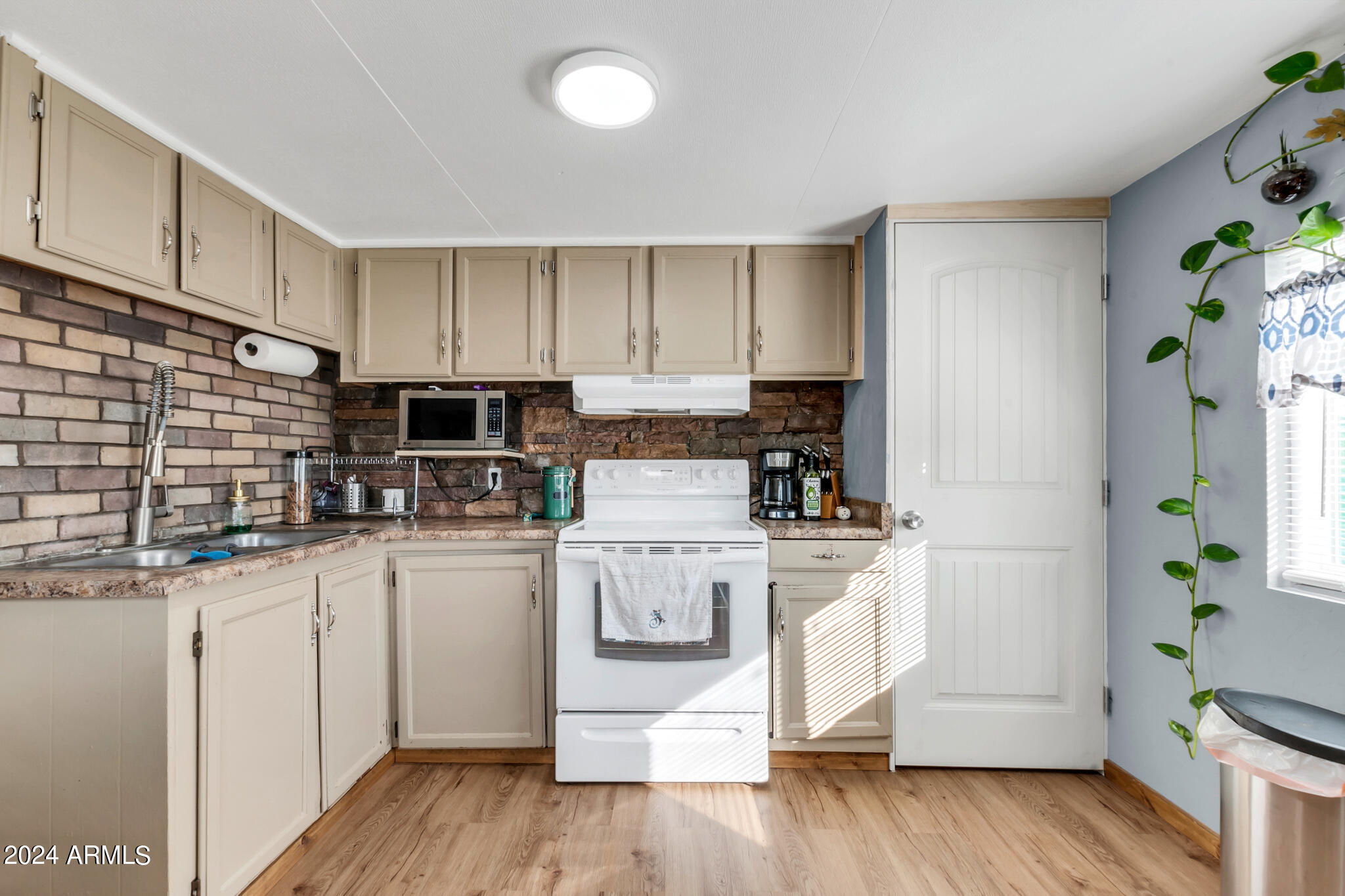 130 East McKellips Road, Unit 48 Mesa, AZ 85201 - Photo 8 of 24 a kitchen with stainless steel appliances white cabinets and a stove top oven