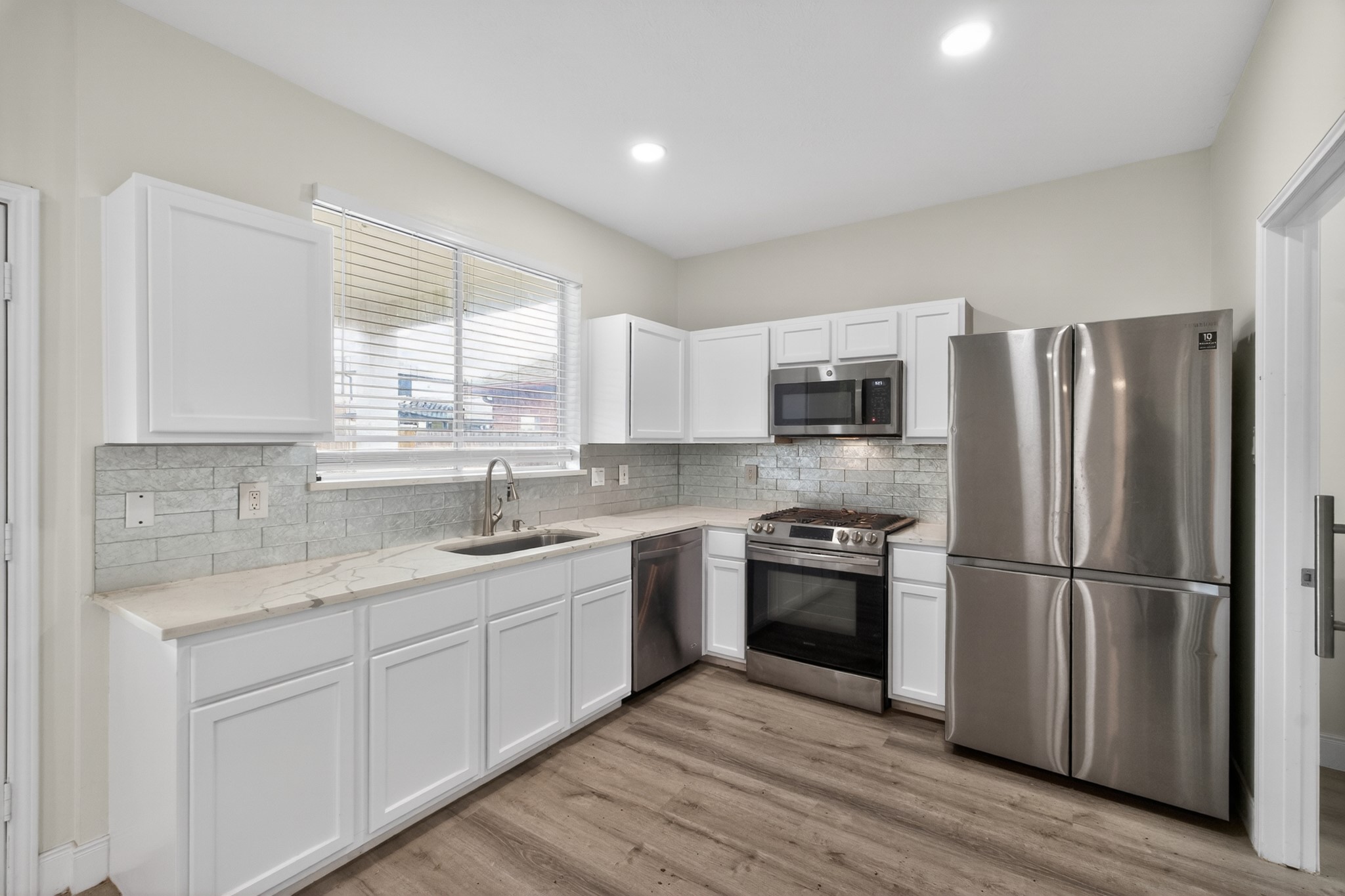 918 Ivycroft Lane Spring, TX 77373 - Photo 11 of 33 a kitchen with a refrigerator sink and wooden floor
