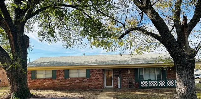 a front view of a house with a tree