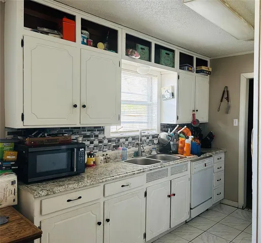 a kitchen with stainless steel appliances a stove a sink and white cabinets