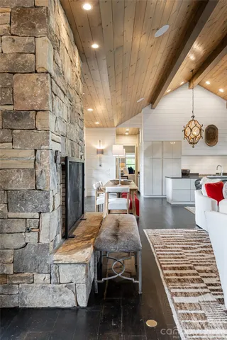 a living room with couches and kitchen view with wooden floor