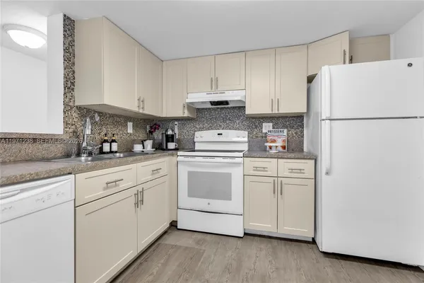 a kitchen with white cabinets and white appliances