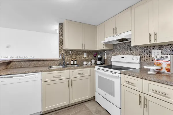 a kitchen with white cabinets and white appliances