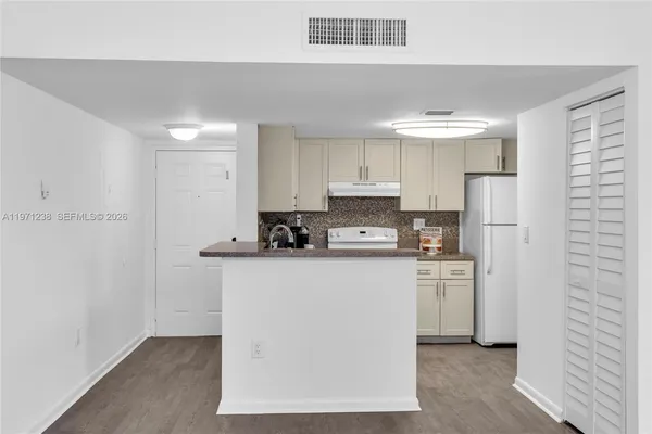 a kitchen with stainless steel appliances a refrigerator sink and white cabinets