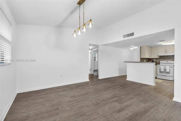 a view of a kitchen with a sink and wooden floor