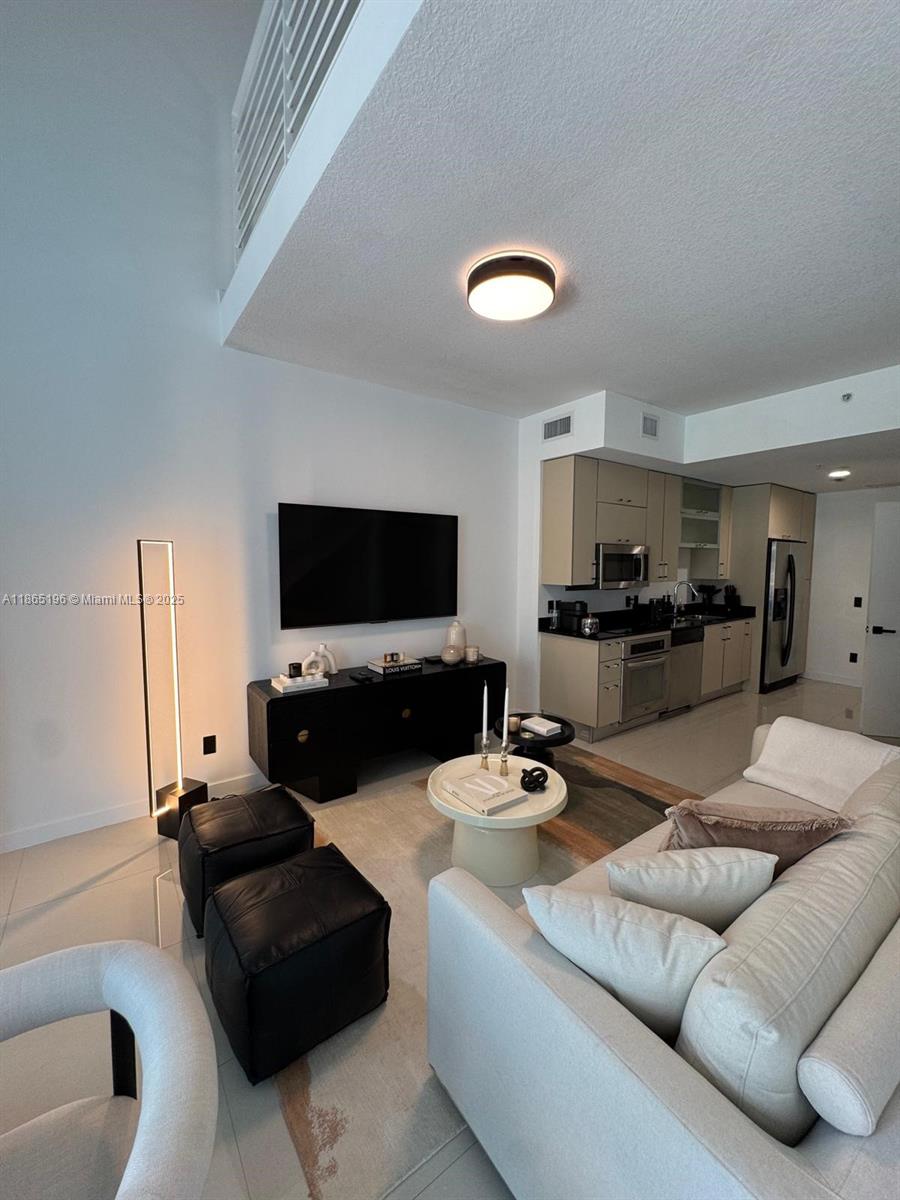 60 Southwest 13th Street, Unit 1406 Miami, FL 33130 - Photo 12 of 19 a living room with furniture and a flat screen tv