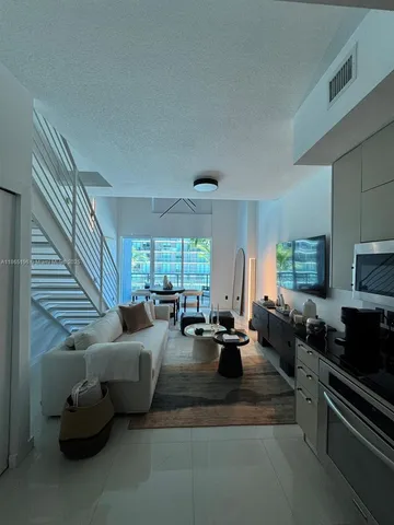 a living room with furniture fireplace and a large window