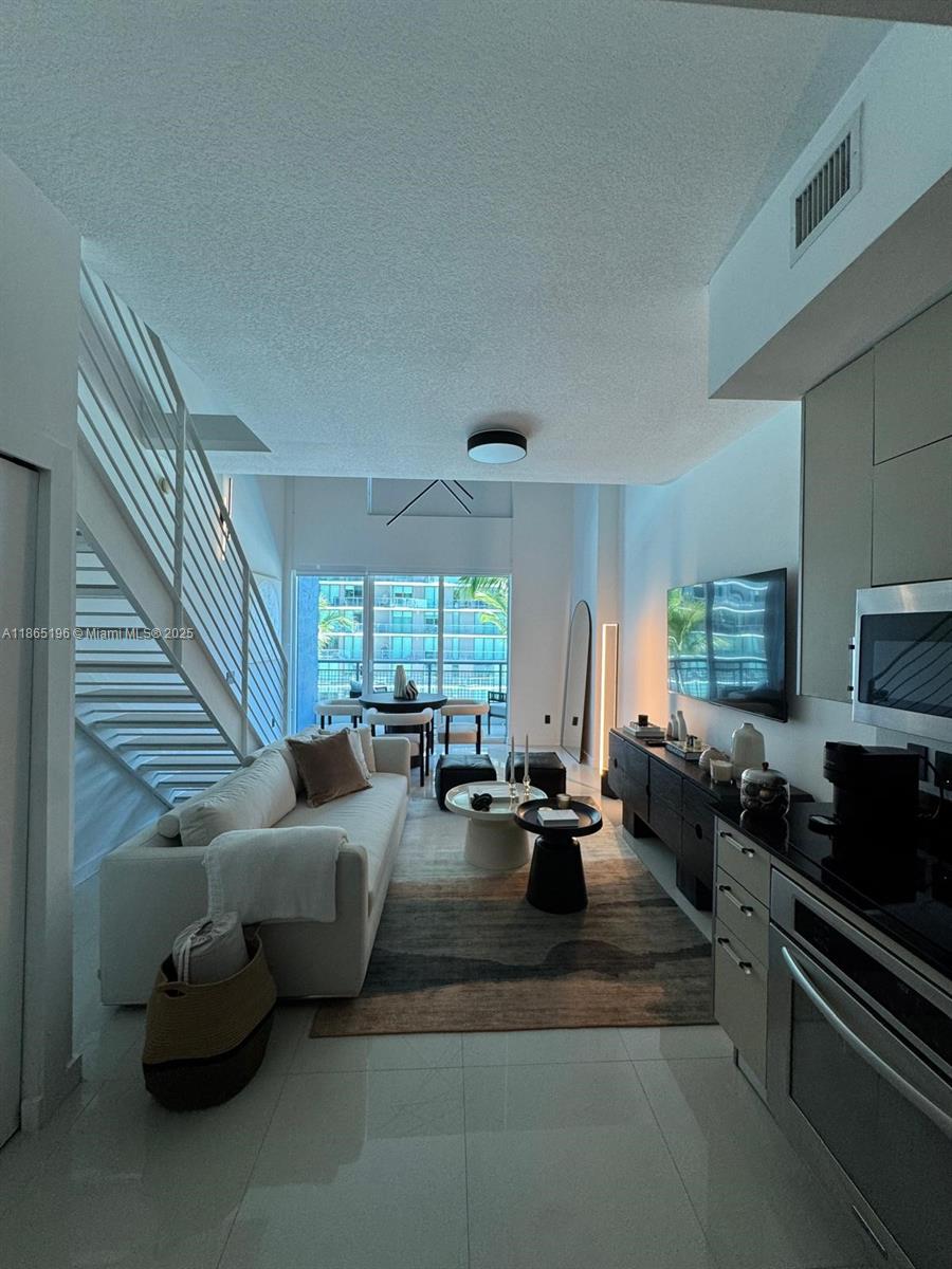 60 Southwest 13th Street, Unit 1406 Miami, FL 33130 - Photo 13 of 19 a living room with furniture fireplace and a large window