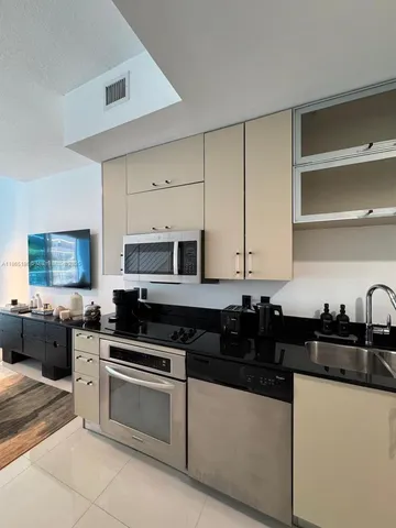 a kitchen with granite countertop a sink a stove and cabinets
