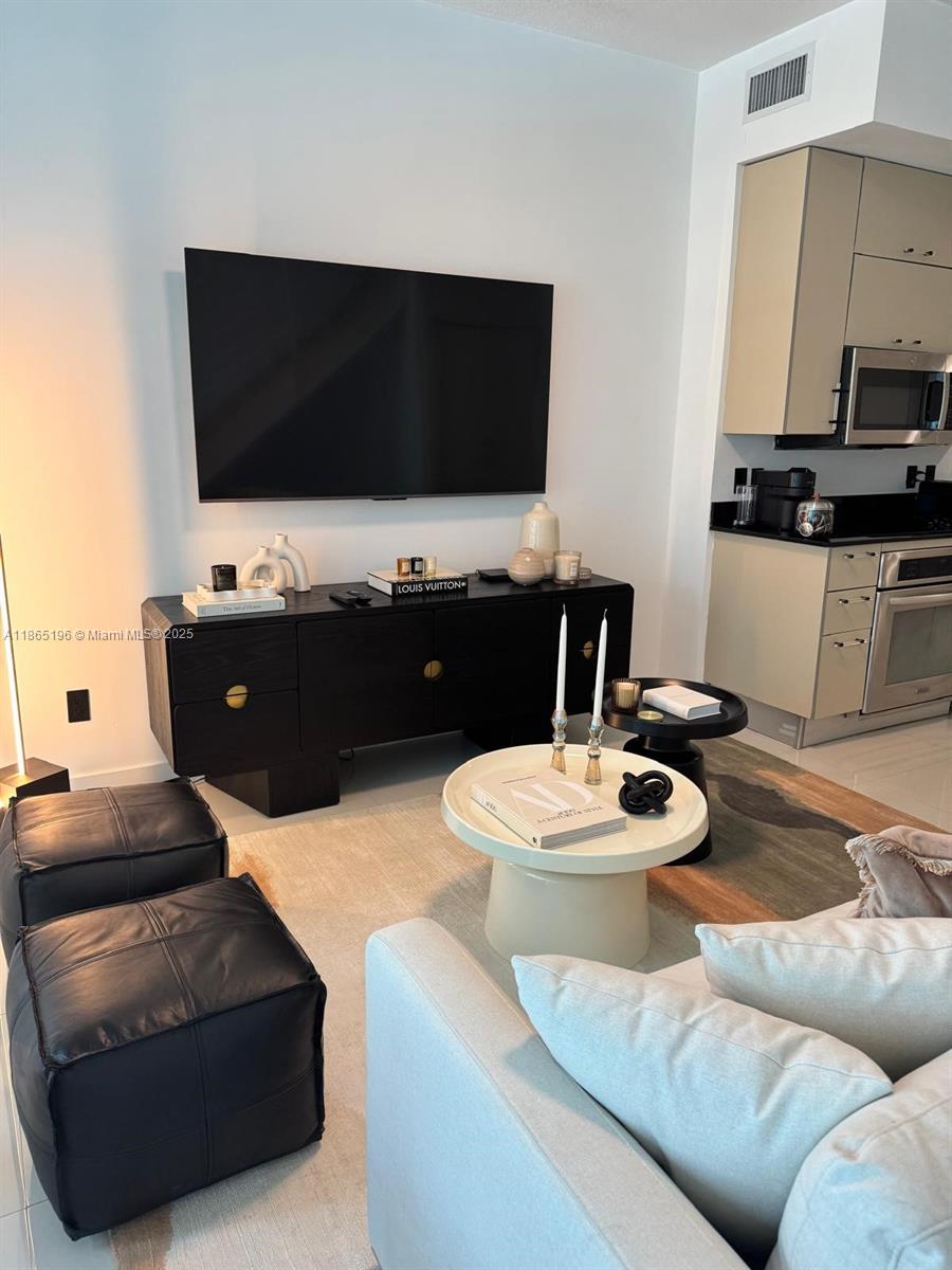60 Southwest 13th Street, Unit 1406 Miami, FL 33130 - Photo 6 of 19 a living room with furniture and a flat screen tv