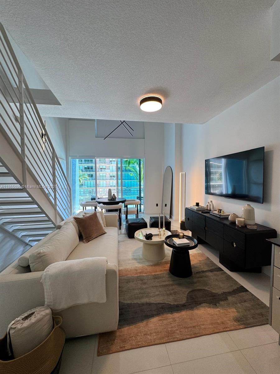 60 Southwest 13th Street, Unit 1406 Miami, FL 33130 - Photo 9 of 19 a living room with furniture and a flat screen tv