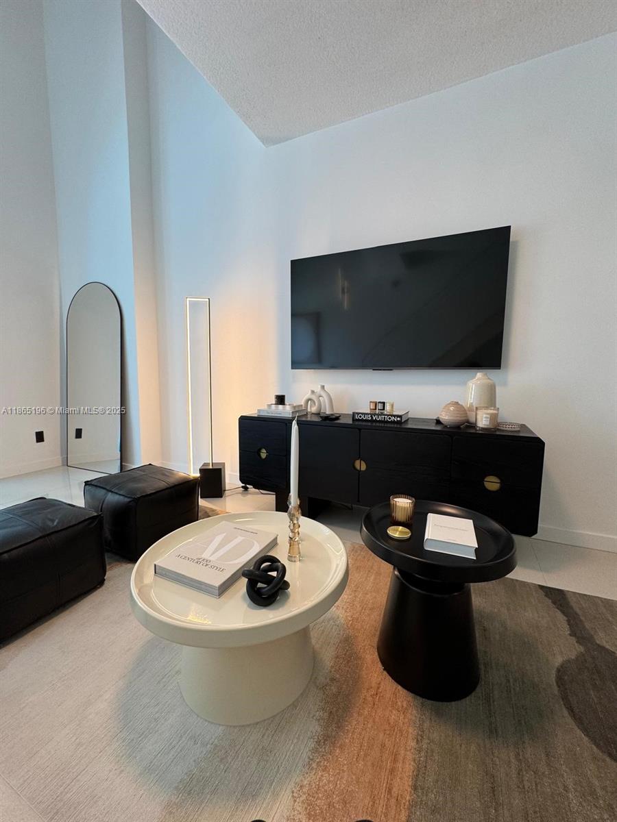 60 Southwest 13th Street, Unit 1406 Miami, FL 33130 - Photo 10 of 19 a living room with furniture and a flat screen tv