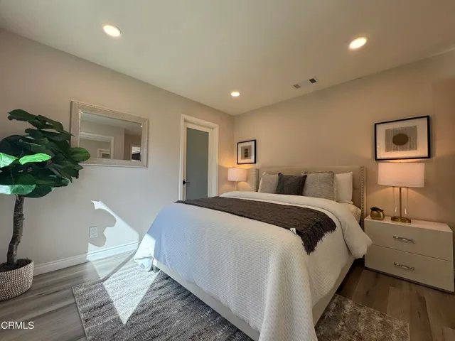 a spacious bedroom with a bed and a potted plant