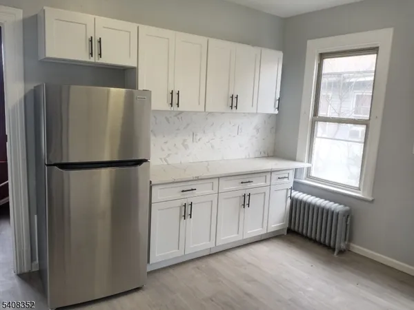 a kitchen with stainless steel appliances granite countertop a refrigerator a sink a stove and cabinets