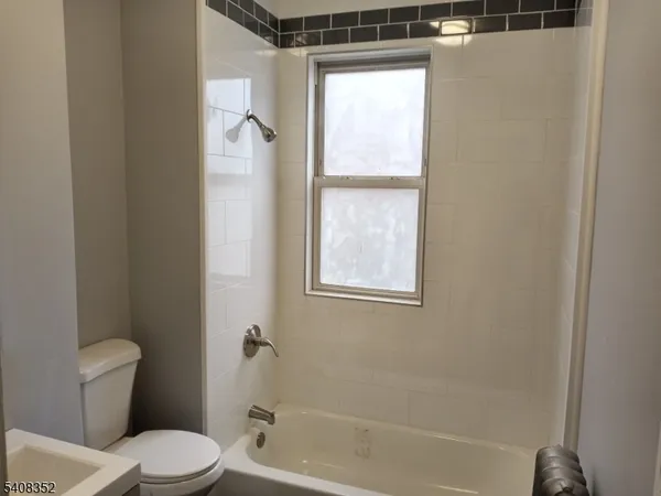 a white toilet sitting next to a bath tub