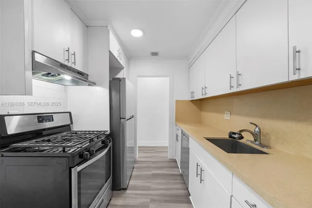 a kitchen with stainless steel appliances granite countertop a sink and a stove