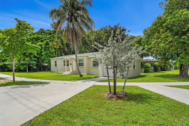 a view of a house with a yard and a palm tree