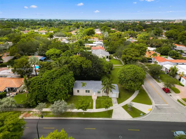 an aerial view of residential houses with outdoor space and swimming pool