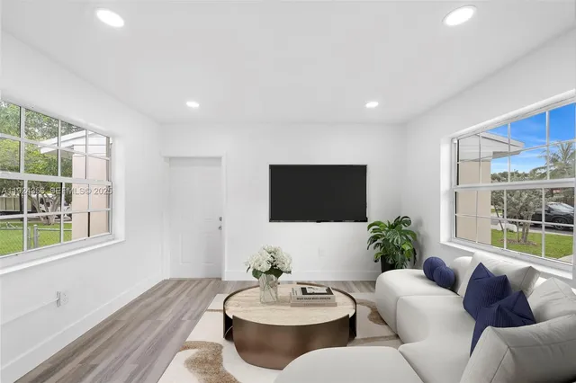 a living room with furniture and a potted plant
