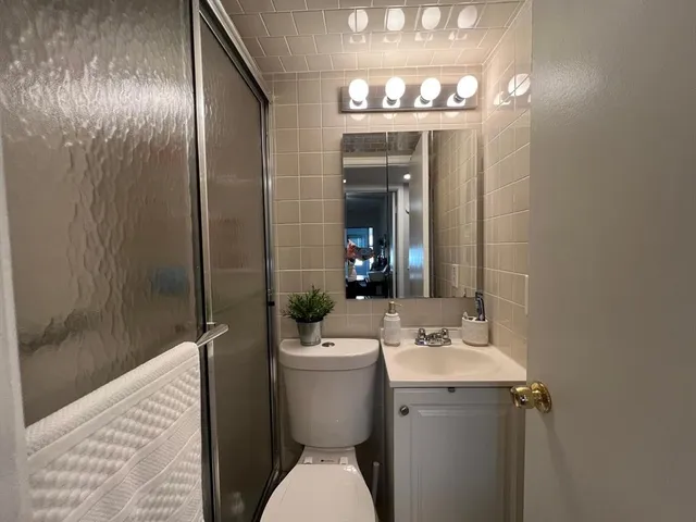 a bathroom with a sink and mirror with toilet