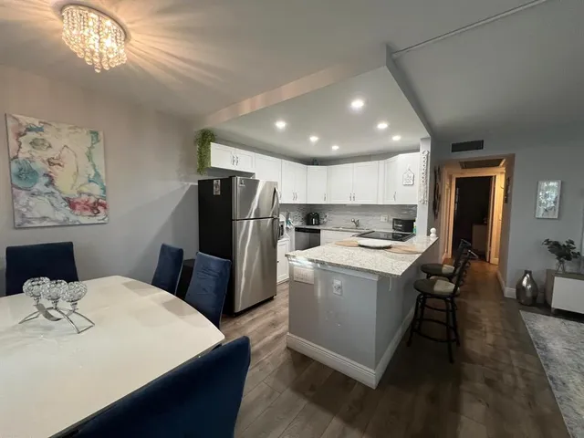 a kitchen that has a lot of cabinets a sink and a refrigerator