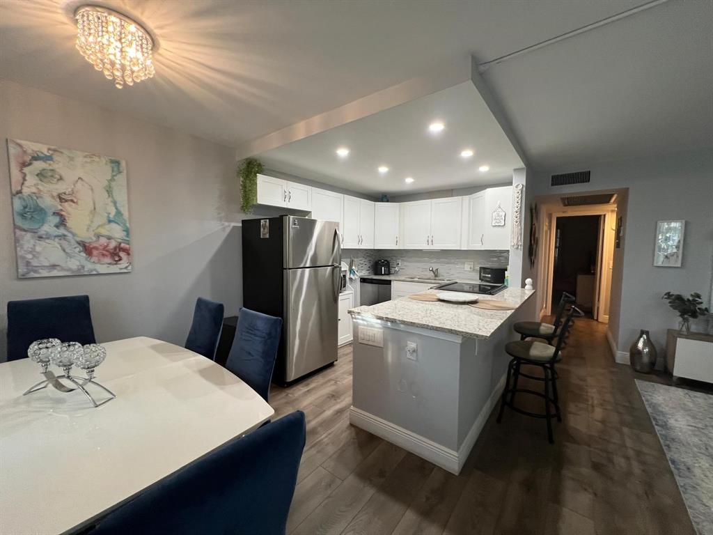 418 Durham, Unit 418 Deerfield Beach, FL 33442 - Photo 25 of 47 a kitchen that has a lot of cabinets a sink and a refrigerator
