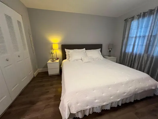 a bed sitting in a bedroom next to a wooden cabinet