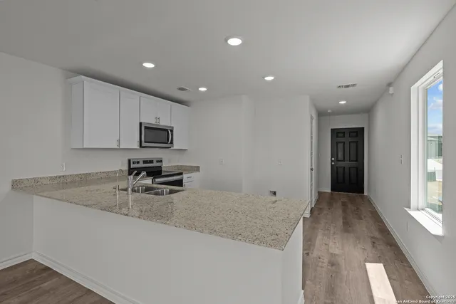 a kitchen with sink refrigerator and microwave