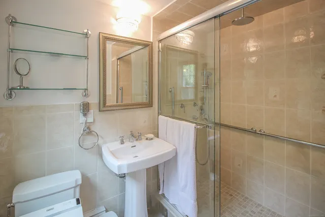 a bathroom with a sink a toilet and shower