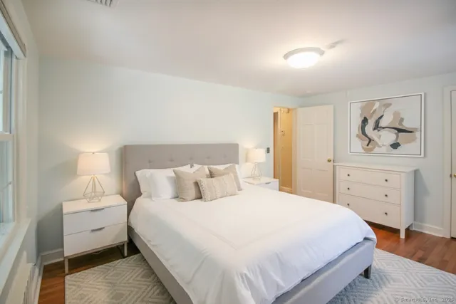 a bedroom with a bed and painting on the wall