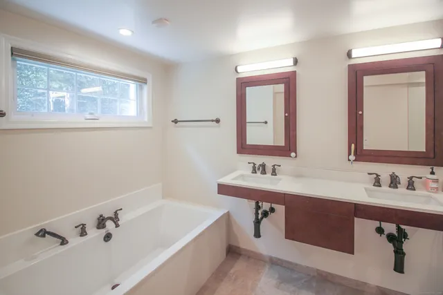 a bathroom with a tub sink and mirror