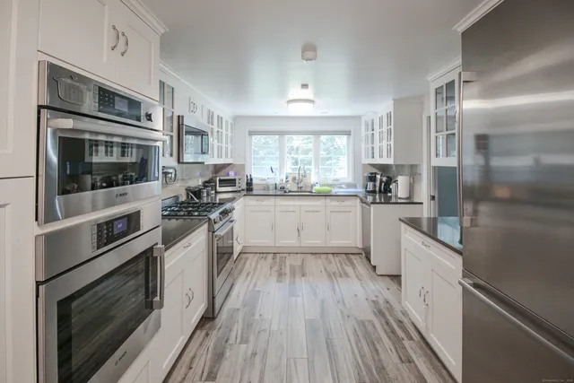 a kitchen with stainless steel appliances a stove a sink and a microwave