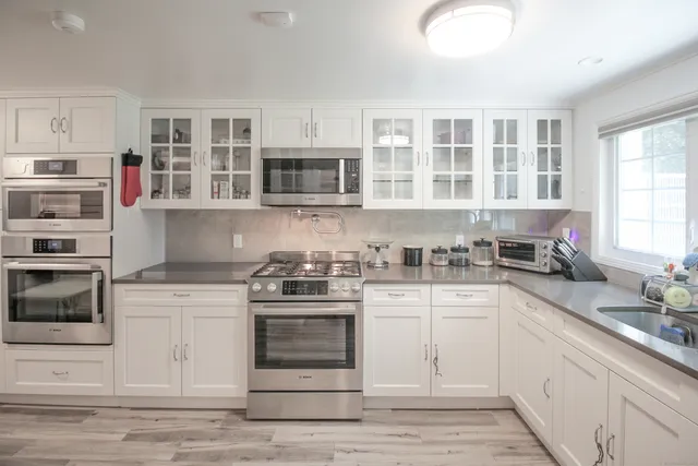 a kitchen with stainless steel appliances granite countertop a stove and cabinets